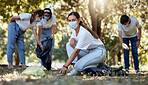 Covid, volunteer and charity with a young woman doing community service and cleaning up the environment with people in the background. Portrait of an eco friendly environmentalist picking up trash
