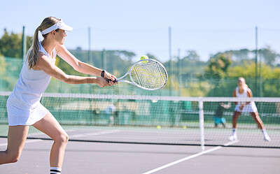 Sports and active tennis player hitting ball with racket equipment during a competitive match or hobby activity on a court. Athletic, sporty and fit woman playing in a tournament game with sportswear