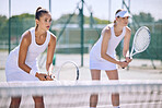 Fit, active and female tennis players ready to play a sports match on the court as a team. Sporty, sportswomen and athletes holding rackets in their hands and are concentrated on winning the game.