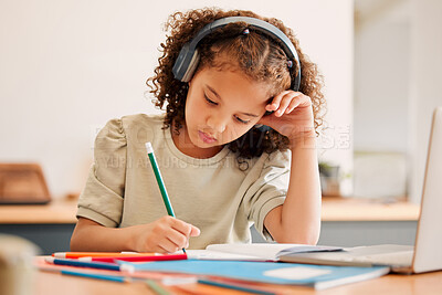Buy stock photo Smart school child, student virtual learning while writing in her book inside an education classroom. Creative with headphones drawing art on paper. Cute, artistic little kid doing homework