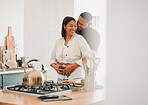 Loving, happy and hugging couple relaxing in the kitchen at home smiling and laughing together. Carefree, excited and affectionate lovers having fun and enjoying quality time in the house