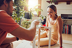Playful, happy and carefree couple painting a table or doing chores together at home and enjoying housework. Joyful, excited and cheerful lovers decorating their house and having fun