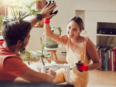 Buy stock photo Couple doing high five, well done or good job gesture while painting or remodelling furniture, wooden table for home improvement or interior decor. A man and woman with fun, creative DIY activity