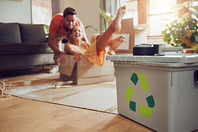 Buy stock photo Fun couple moving into new house, playing with boxes and being playful after relocation to apartment together. Carefree man and woman recycling at home, living sustainable and reducing waste
