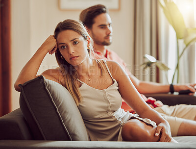 Buy stock photo Unhappy, sad and annoyed couple after a fight and are angry at each other while sitting on a couch at home. A woman is stressed, upset and frustrated by her boyfriend after an argument