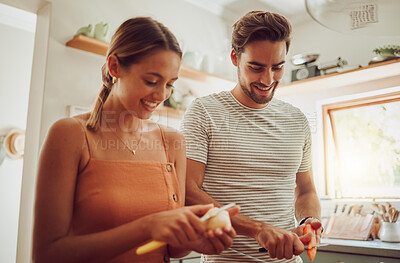 Buy stock photo Happy couple cooking fresh vegetables and healthy food in the kitchen together at home for dinner time. In love, romantic and young husband and wife cutting natural organic consumables for their diet