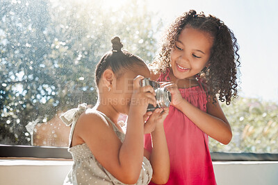 Buy stock photo Cute sisters bonding, taking photos on camera at home, smiling while being playful and curious. Little girls playing, having fun together, enjoying their bond and sharing precious childhood moments
