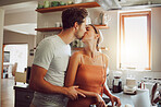 Romantic couple kissing, cooking and showing affection in love while bonding together in a kitchen at home. Caring boyfriend and girlfriend in a loving relationship sharing an intimate special moment