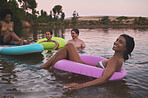 Vacation, swimming and diverse friendship having fun in a lake while enjoying summer. Happy friends relaxing in calm water while talking and laughing. Smiling multiracial people bonding on a getaway.