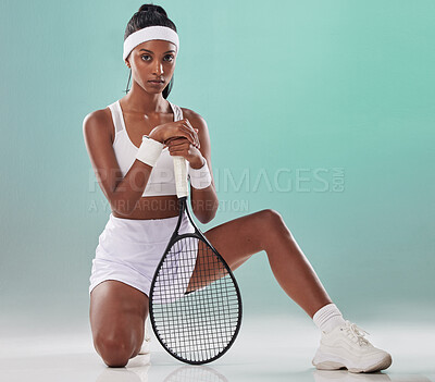 Buy stock photo Tennis, sports and training with a woman player posing with a racket in studio against a green background. Portrait of a young, active and healthy athlete looking serious and ready to compete
