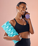 Fitness, active and healthy woman holding a dumbell, foam roller and smile after sports training against studio background. Happy fit lady feel slim, happy and cheerful after gym, workout or exercise