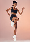 Active, healthy, sport and fitness athlete is determined and focused on her running exercise workout. Young woman with fit body, wearing gym sportswear, doing cardio training in studio background