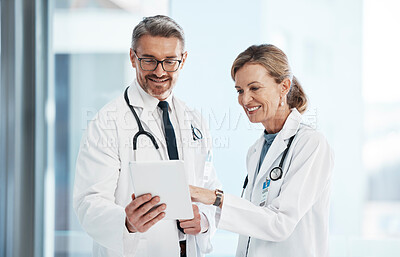 Buy stock photo Medical, doctors and healthcare professionals working together on a digital tablet in a hospital. Portrait of a mature female and male doctor smiling and discussing diagnosis in a clinic.