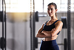  Fit, slim and serious woman with arms crossed, feeling confident about her body and health while standing in gym. Portrait of a sporty and determined woman ready to exercise to stay in healthy shape