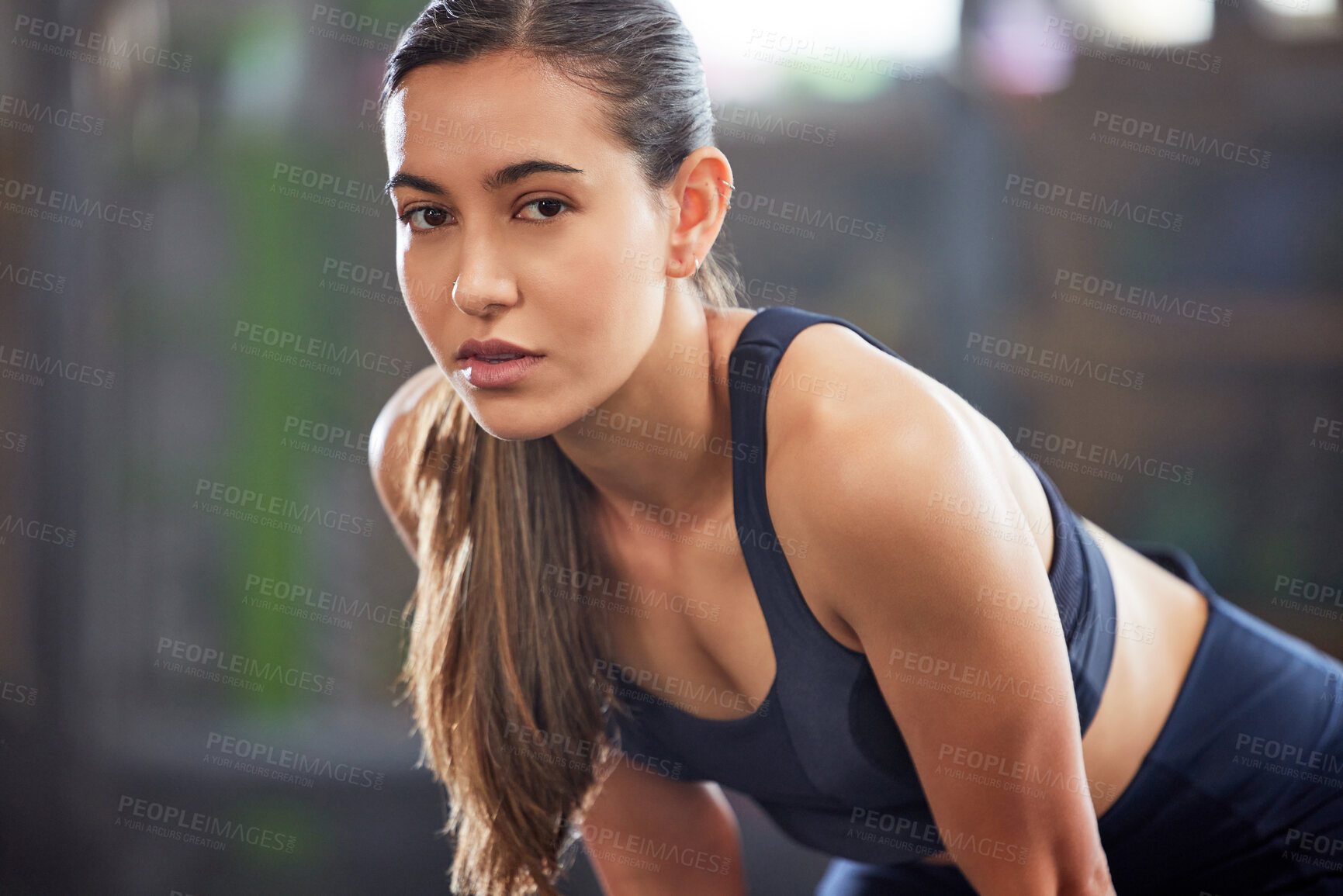 Buy stock photo Fitness, gym and athletic woman taking a break and resting after a workout. Portrait of a fit and healthy woman looking tired after exercising and being active at a health and wellness facility