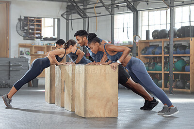 Buy stock photo Group training, incline push up and bodyweight exercise, workout and fitness in a gym class with plyometric jump boxes. Sporty, strong and active people with endurance, energy and wellness challenge