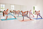 Fitness, yoga and exercise class fit a group of women doing poses on their mats in a fitness studio. Diverse and active females exercising and working out during pilates for health and balance 