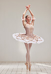 Graceful female ballerina posing or dancing, performing dance or a practice performance in studio. Young beautiful and elegant ballet dancer in a dress or tutu costume doing pointe technique on toes