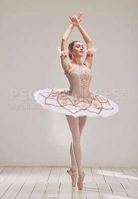 Buy stock photo Female ballerina doing ballet dance, dancing or performing during a practice rehearsal in studio. Young dancer or artist in a tutu costume dress and shoes doing pointe technique on toes performance