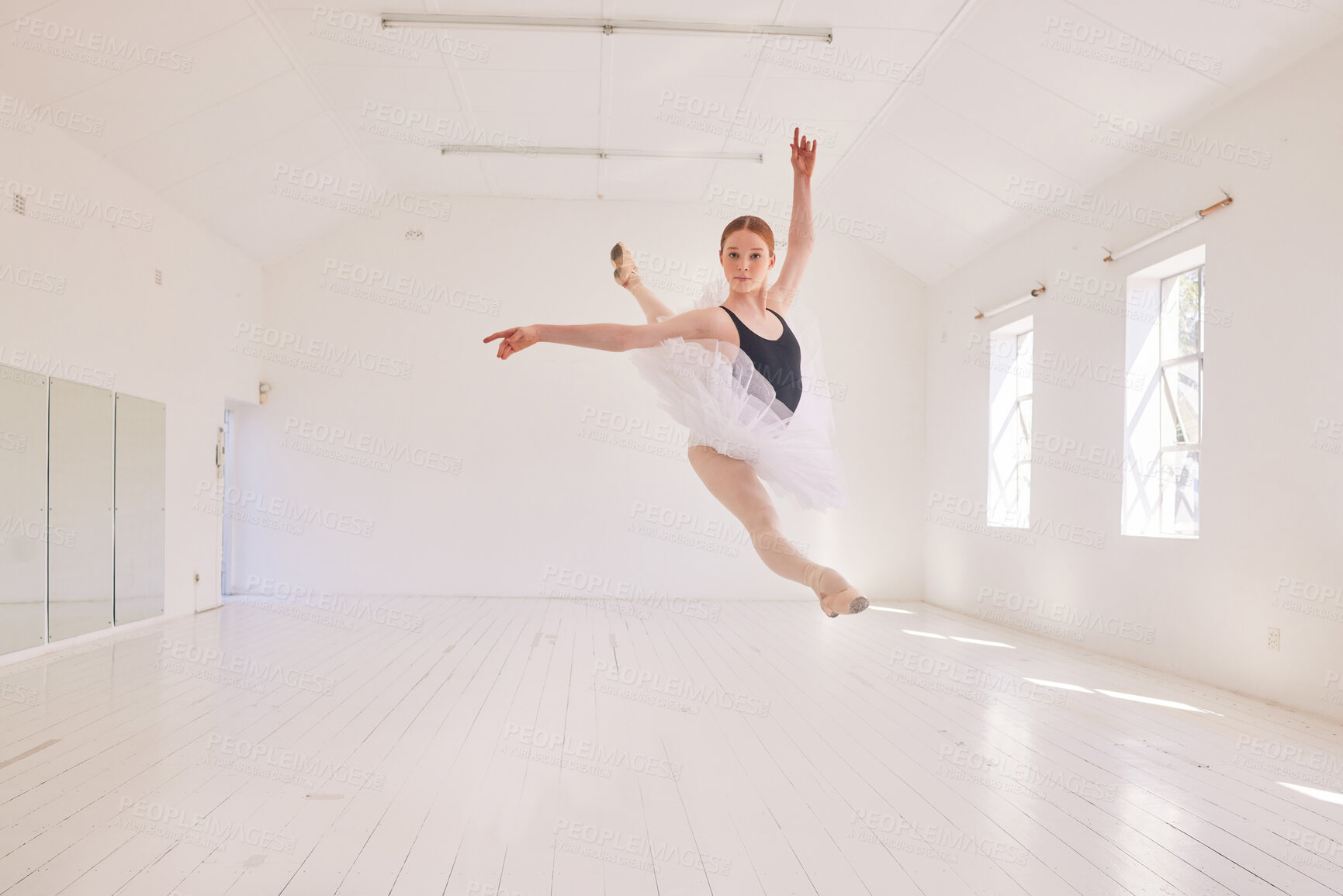 Buy stock photo Ballet dancing and jumping practicing in a dance studio or class preparing for a performance. Young elegant dancer, performer or ballerina in the air performing and leaping high