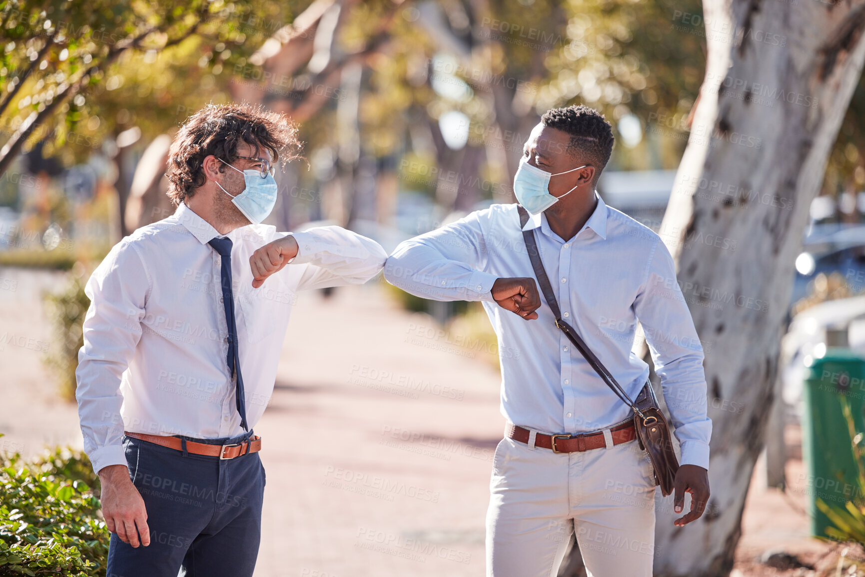 Buy stock photo Businessmen elbow greeting in covid 19 masks outside in a parking lot showing teamwork and diversity in summer. Sun, world and social safety protocol by people who work for a global corporate company