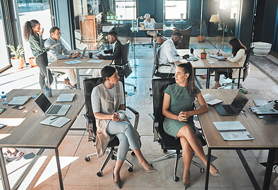 Buy stock photo Open office space policy business people having in formal discussion at their desk in a busy, collaboration corporate workplace. Professional employee or staff talking while working on company plan