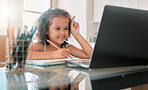 Cute, adorable and smart little girl attending online homeschooling using home internet and a laptop. An intelligent young child doing virtual learning using a school website or app