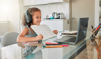 Buy stock photo Distance learning, education and a little girl in virtual class on a laptop, smiling and showing her picture on video call. Happy child proud of her homework, having fun online while sitting at home