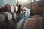 Winemaker businesswoman with white wine tasting glass, Chardonnay or quality alcoholic drink in winery, factory or warehouse. Entrepreneur in hospitality, winemaking industry testing flavor in cellar
