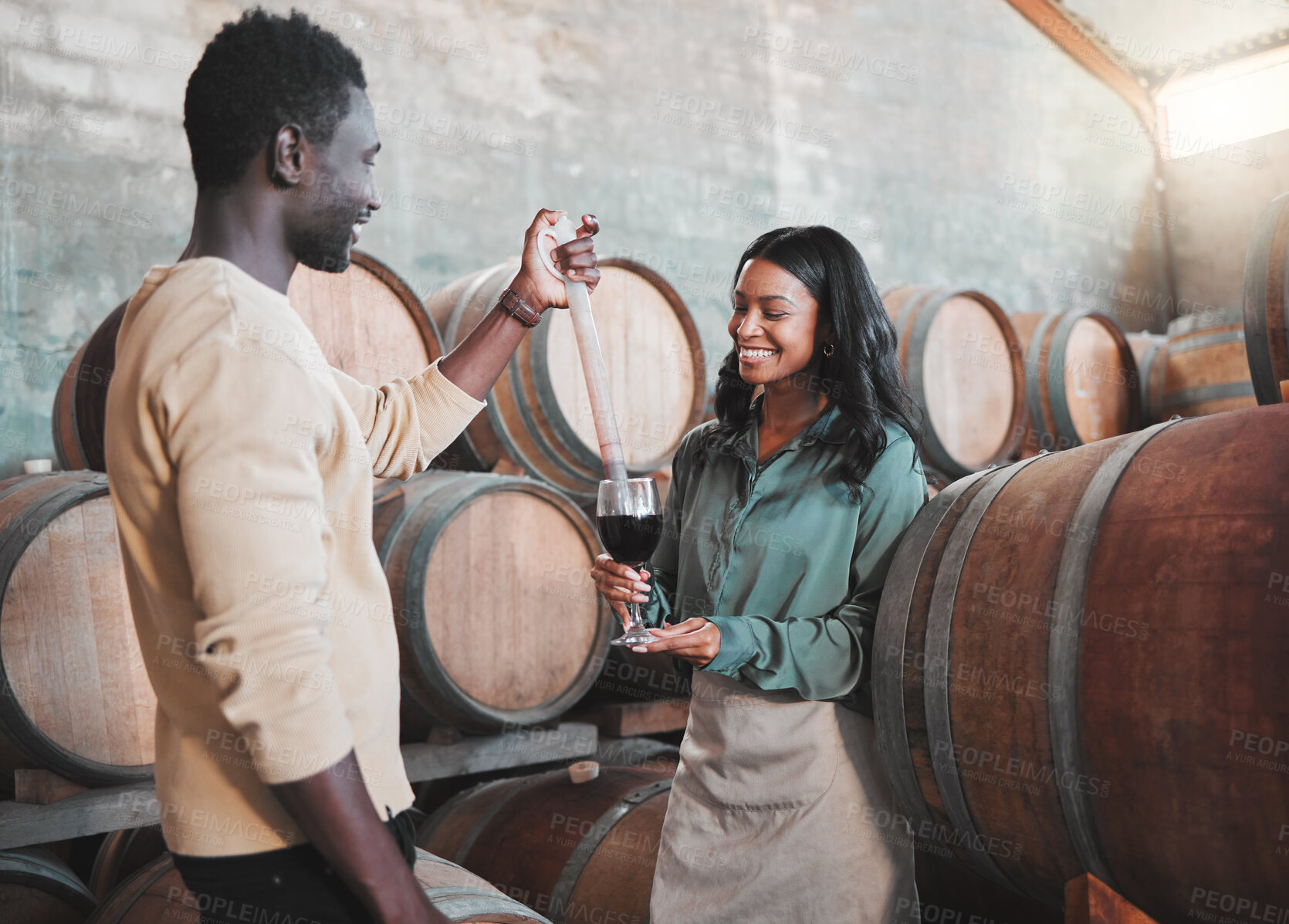 Buy stock photo Wine tasting, couple and distillery farm worker serving red alcohol drink in glass with pipette in countryside. Happy smile, learning man and woman or winery waiter on sustainability luxury vineyard