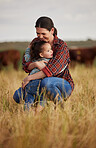 Love, family and care with a mother and daughter hugging in a field outside on a farm. Cattle farmer and little girl in the farming, agricultural and dairy industry on a meadow or pasture outdoors