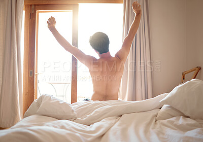 Buy stock photo Man in nude stretching after night sleep in bed, waking up to morning sunrise in bedroom and feeling excited for day at home. Back of naked male person relaxing after nap or rest in apartment house