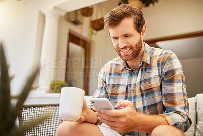 Buy stock photo Phone, coffee and communication with a man on a social media app and mobile technology at home. Tea, relax and internet with a young male reading and typing a message while sitting in the living room
