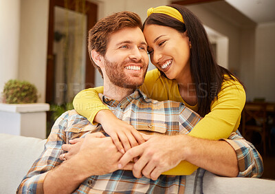Buy stock photo Diversity, love and happy couple in living room sofa together, sharing intimate moment at home. Freedom, smile and relax young married man embracing woman bonding on marriage anniversary 