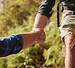 Support, teamwork and helping hands by hikers hiking outdoors in nature on a mountain trail. Fit and active friends help each other closeup and while trekking and climbing tough terrain