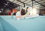 Gymnast man stretching legs at gym with flexibility fitness exercise or workout training for sports competition start.  Healthy young sport athlete train for cardio, energy and body performance goal