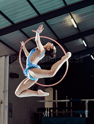 Buy stock photo Sports woman, performance and ring in the air for gymnastics show. Fitness girl doing artistic pose and stretch for acrobat stunt. Young and beautiful athlete in gym with hula hoop and flexible body.