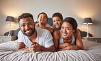 Portrait of happy black family bonding on a bed, carefree, relaxing and playing in a bedroom together. Young loving parents enjoying free time with their children, being playful and showing affection
