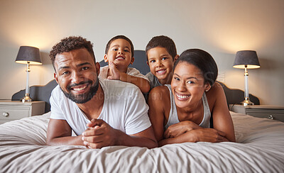 Buy stock photo Portrait of happy black family on a bed with children, carefree, relaxing and playing in a bedroom together. Young parents enjoying morning bonding, being playful and showing affection
