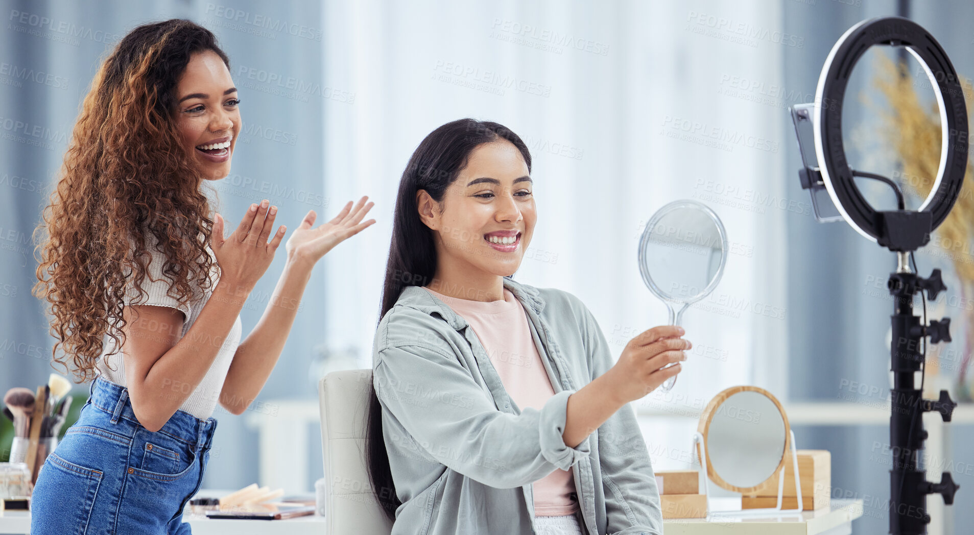 Buy stock photo Woman recording a makeup tutorial with a client for her beauty blog or vlog using her phone at home. African American female influencer live streaming her cosmetic skills for social media