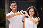 Happy couple with key and heart hand sign with a smile after buy real estate together. Man and woman with keys or happiness with property rent or purchase of house, family home or apartment with love