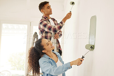 Buy stock photo Painting, love and renovation with a couple doing DIY in a room for improvement and remodel of their home. Young man and woman working with green paint on a wall to renovate their domestic house