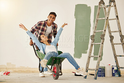 Buy stock photo Love, teamwork and renovation, couple paint a wall in a house green. Happy, creative and playful, new home owners do repair work on home. Wheelbarrow, ladder and painting, man and woman have diy fun