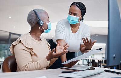 Buy stock photo Manager consulting a call center agent about business paperwork with face masks in covid pandemic. Black, young and customer support worker discussing a work mistake with her mentor in an office.