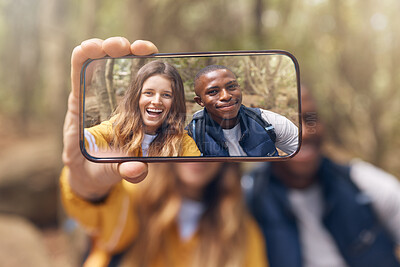 Buy stock photo Happy couple taking a selfie on a phone while in nature on a romantic date in the forest. Multiracial, love and traveling man and woman taking picture with smartphone camera after hiking in the woods