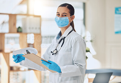 Buy stock photo Portrait of a doctor with paper and face mask doing medical paperwork during covid pandemic. Healthcare worker reading coronavirus results on a clipboard of hospital patient while standing in clinic.
