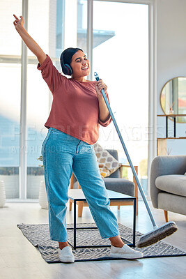Buy stock photo Woman, singing and dancing while cleaning living room for fun domestic work, hygiene and cleanliness at home. Happy female listening to music enjoying housework, sing and dance with broom stick