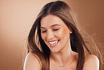 Woman, laughing face or skincare glow on studio background in self love, dermatology treatment or keratine hair style. Smile, happy or brunette beauty model in facial healthcare, wellness or collagen