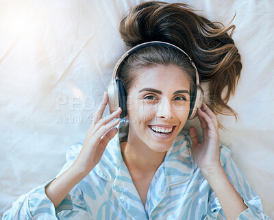 Buy stock photo Top view, woman and headphones in bedroom to relax for morning wellness on podcast, audiobook streaming and music in Australia. Portrait, face and happy girl listening to radio, sound and media track