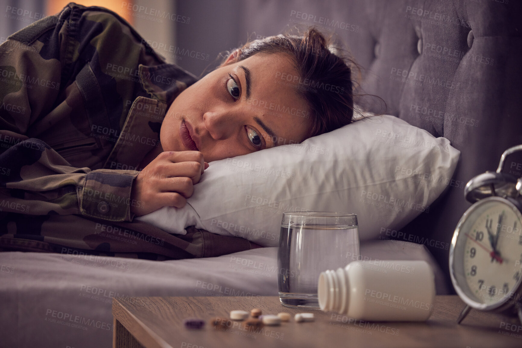 Buy stock photo Depressed woman, bed and medicine for insomnia, mental health and anxiety of military soldier with stress, depression and trauma. Army female in bedroom with ptsd, pills and thinking about drugs